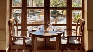 Un comedor con una mesa y sillas, un gran ventanal de arco y vistas al exterior.