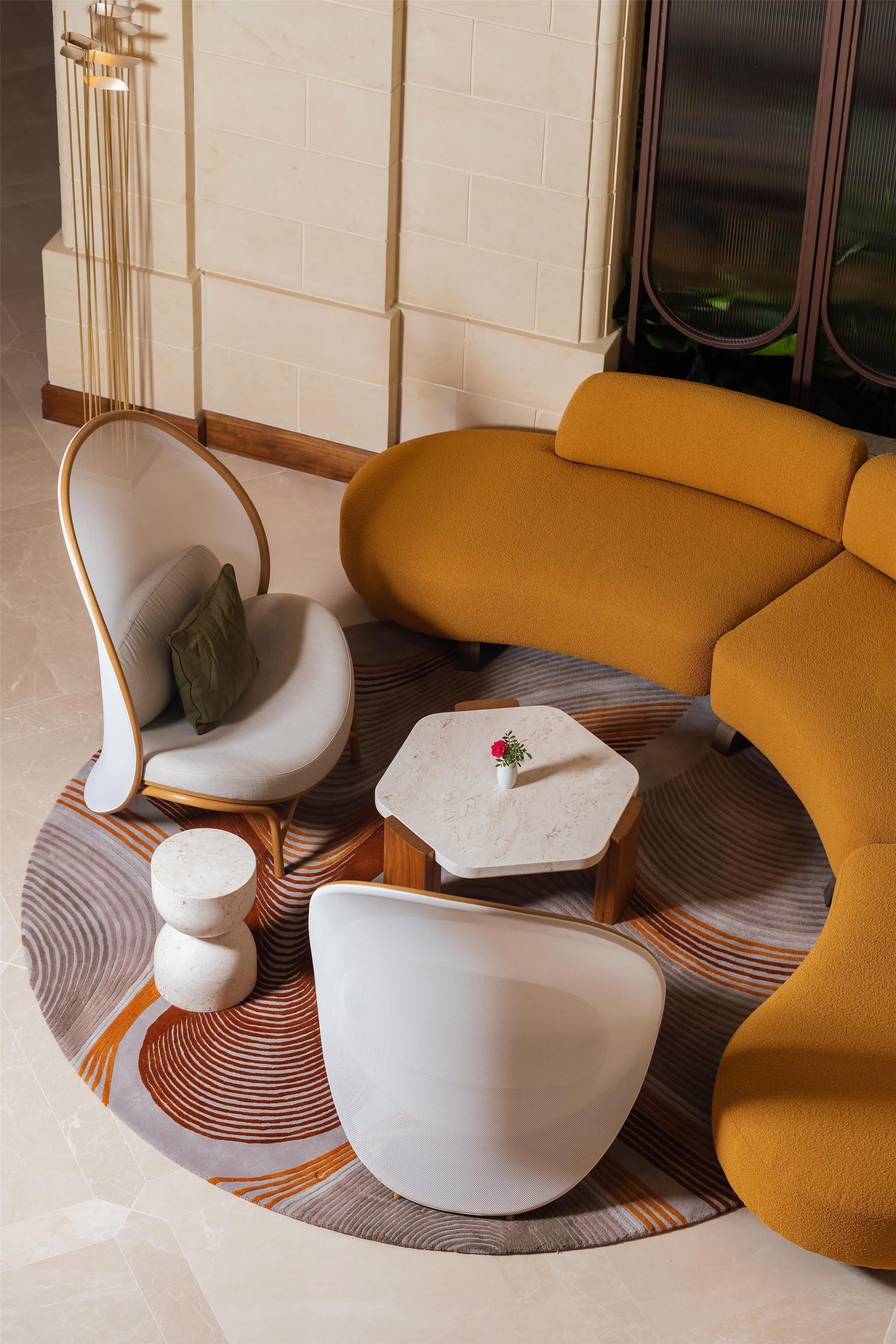 En moderne stue med sofa, stole, et lille bord og en dekorativ vase.