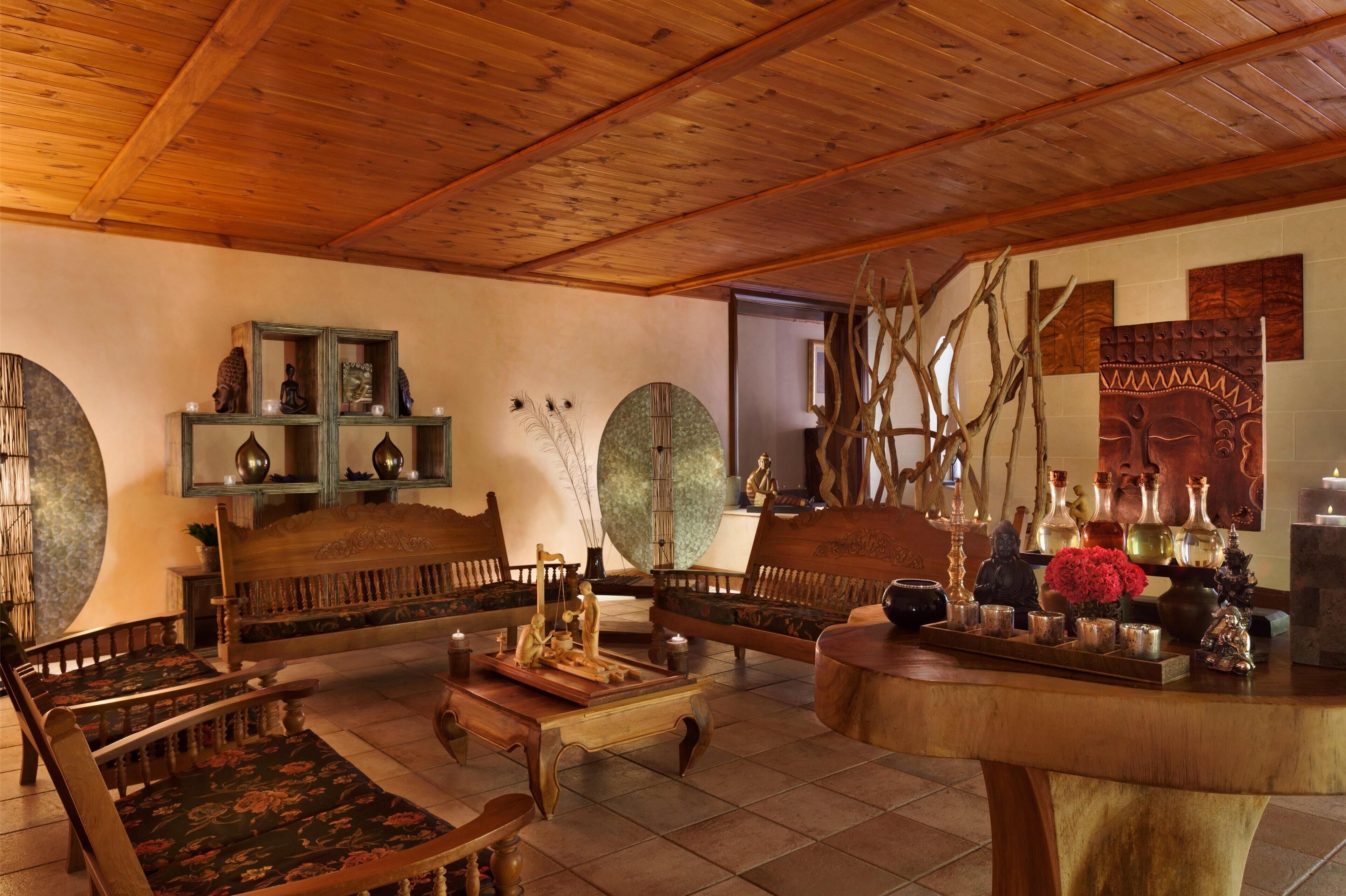 A traditional room with wooden furniture, a central table, and decorative items.