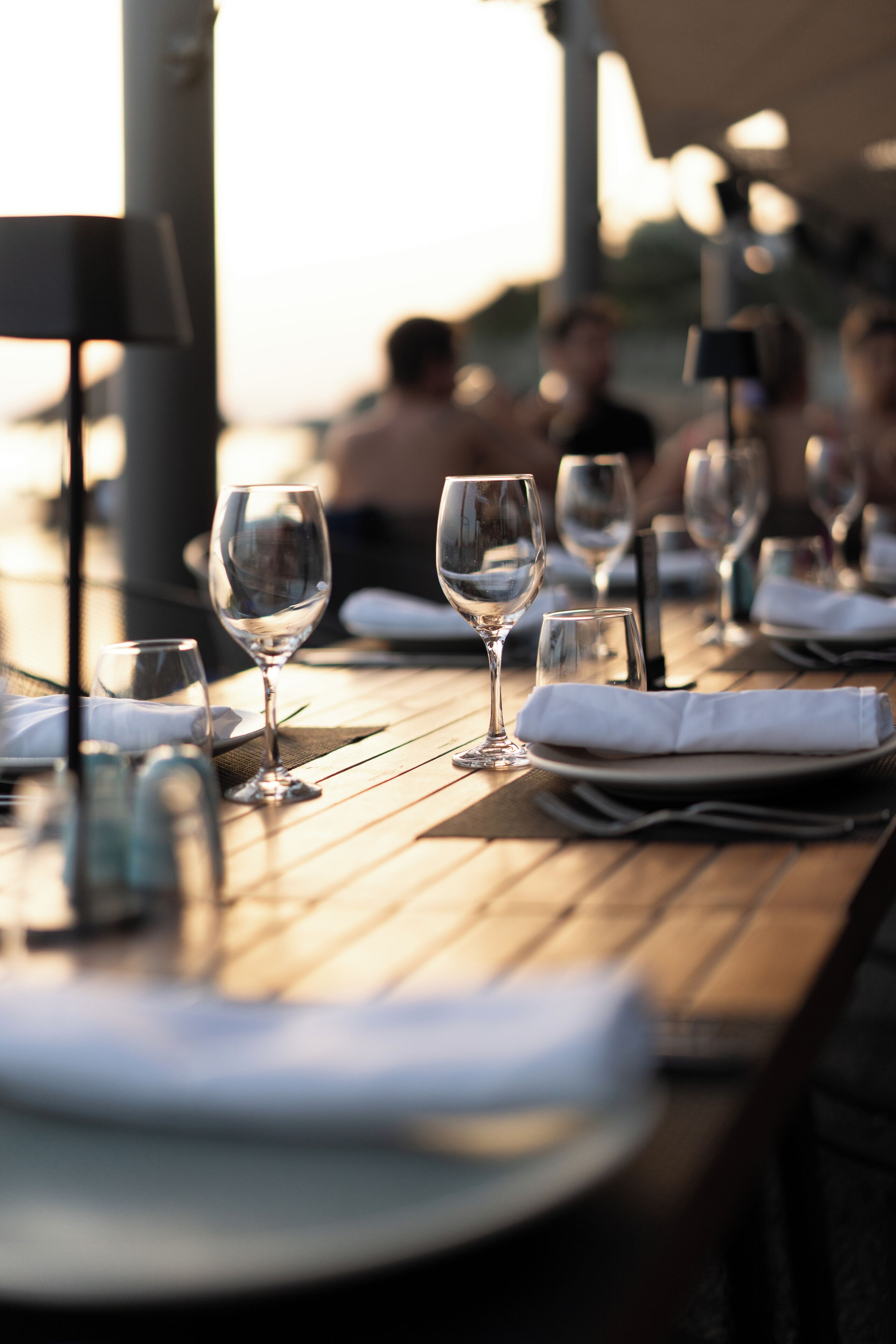 A dining table with empty wine glasses and plates, suggesting a restaurant setting.