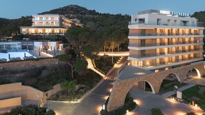 Un hôtel à plusieurs étages, doté d’une architecture moderne, avec des balcons et un pont en pierre.