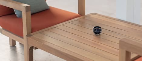 Una mesa de madera con un pequeño adorno, rodeada de sillas de madera con cojines.