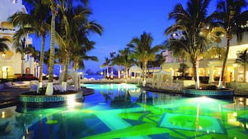 Een buitenzwembad, parasols bij het zwembad en ligstoelen