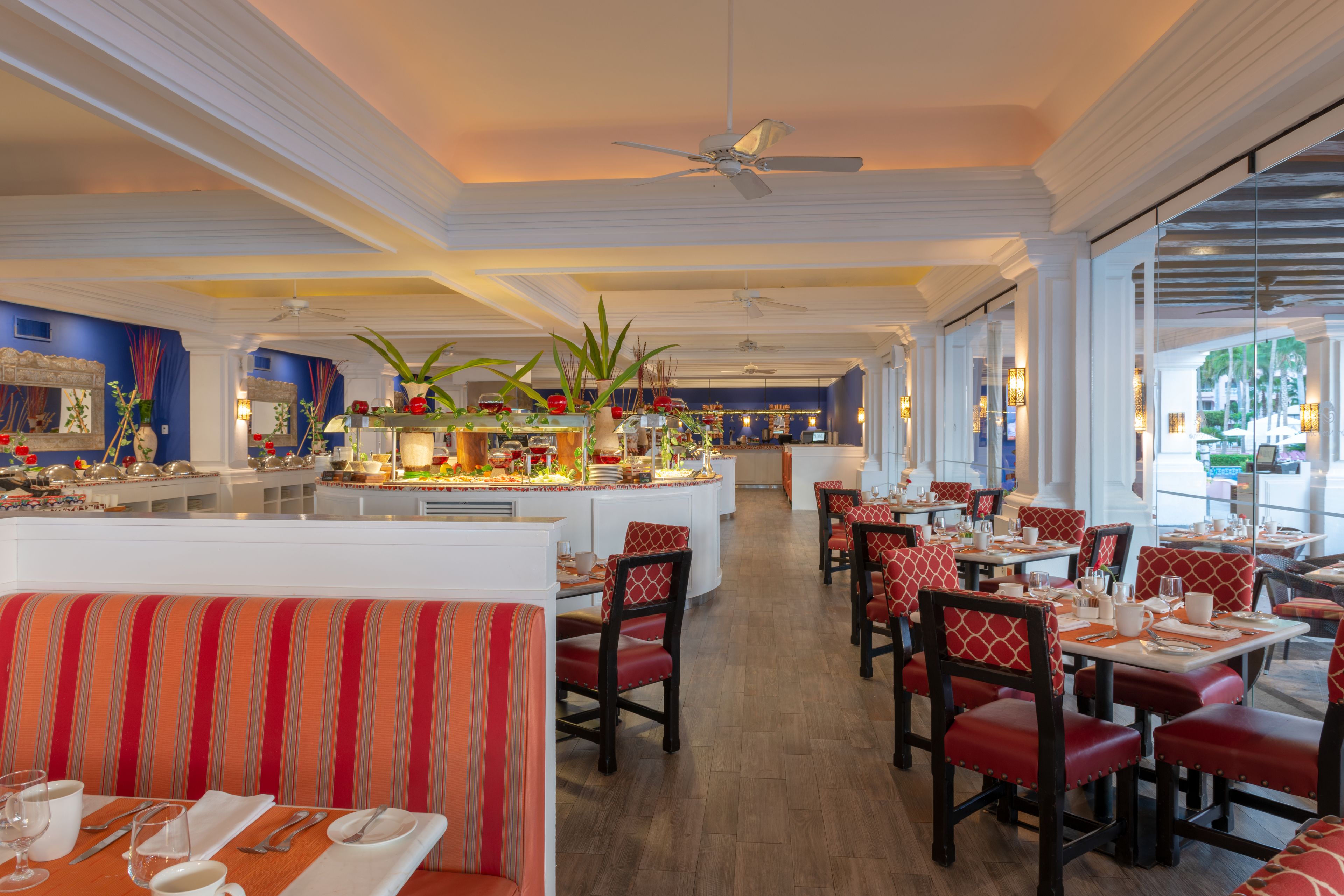A restaurant with high ceilings, a central bar area, and multiple dining tables and booths.