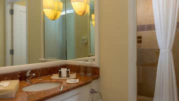 A bathroom with two sinks, a large mirror, and a shower area with a curtain.