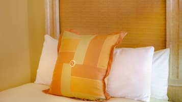 Un letto con due cuscini, uno con motivo geometrico e l'altro semplice.