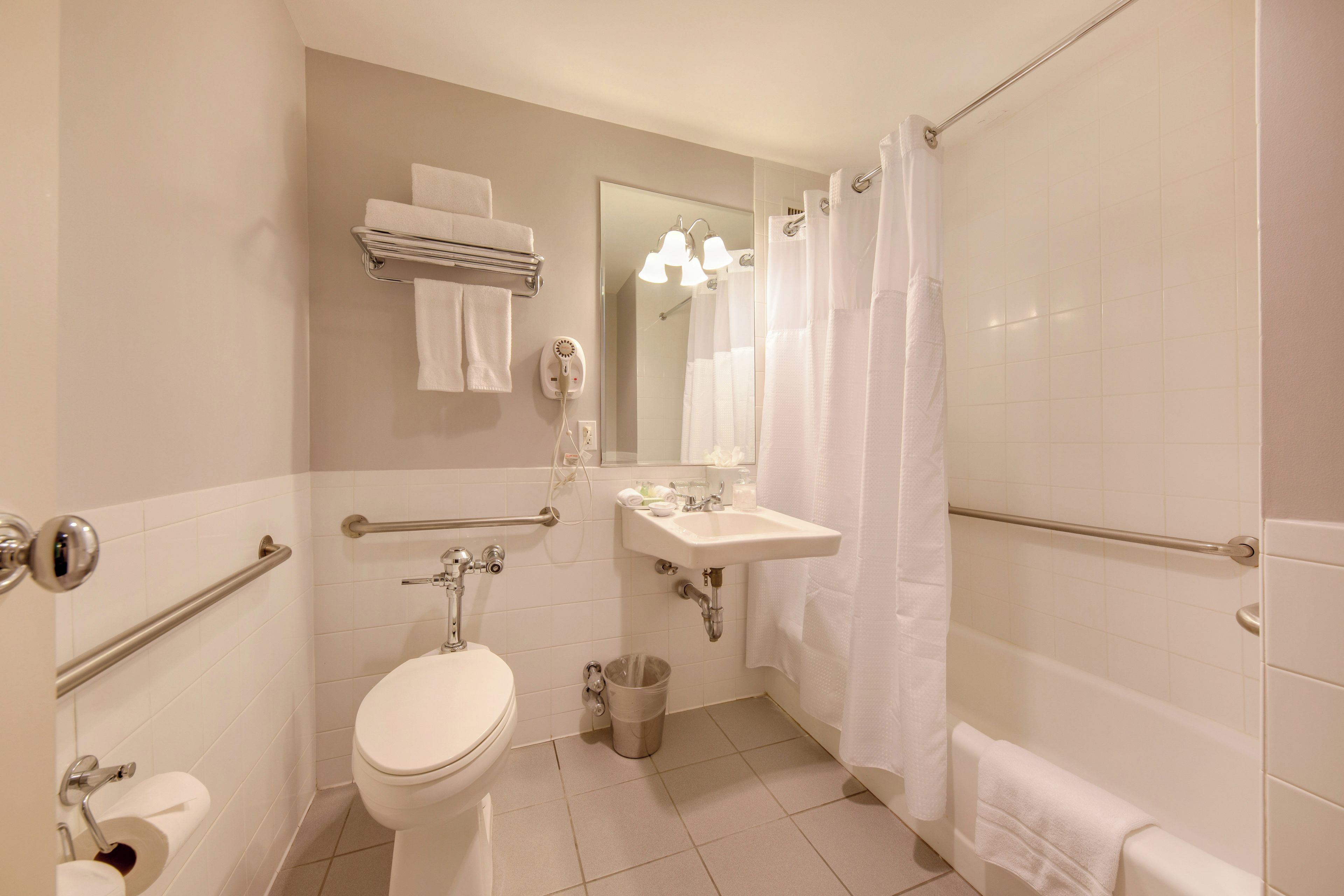 A modern bathroom with a toilet, sink, and shower.