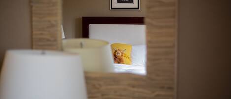A hotel room with a bed, a lamp, and a framed picture on the wall.
