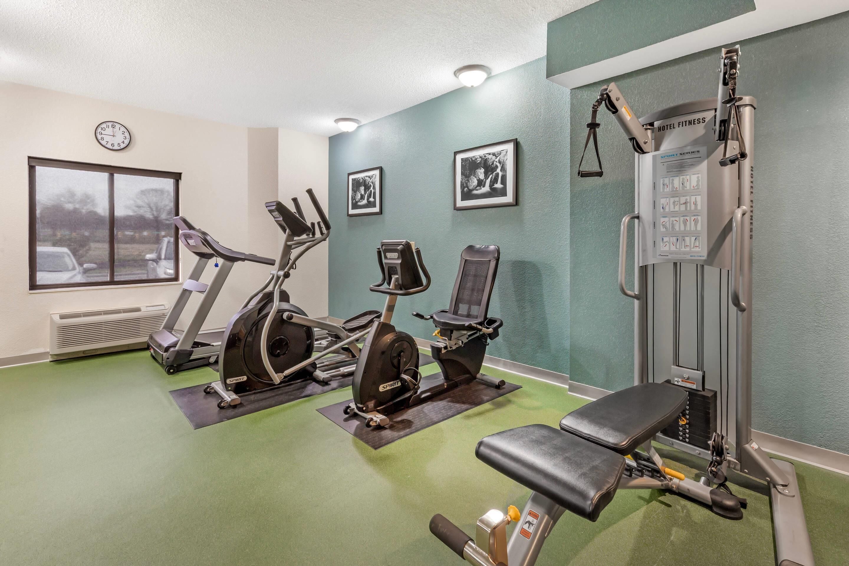 A gym with treadmills, an elliptical, a bench press, and a weight machine.
