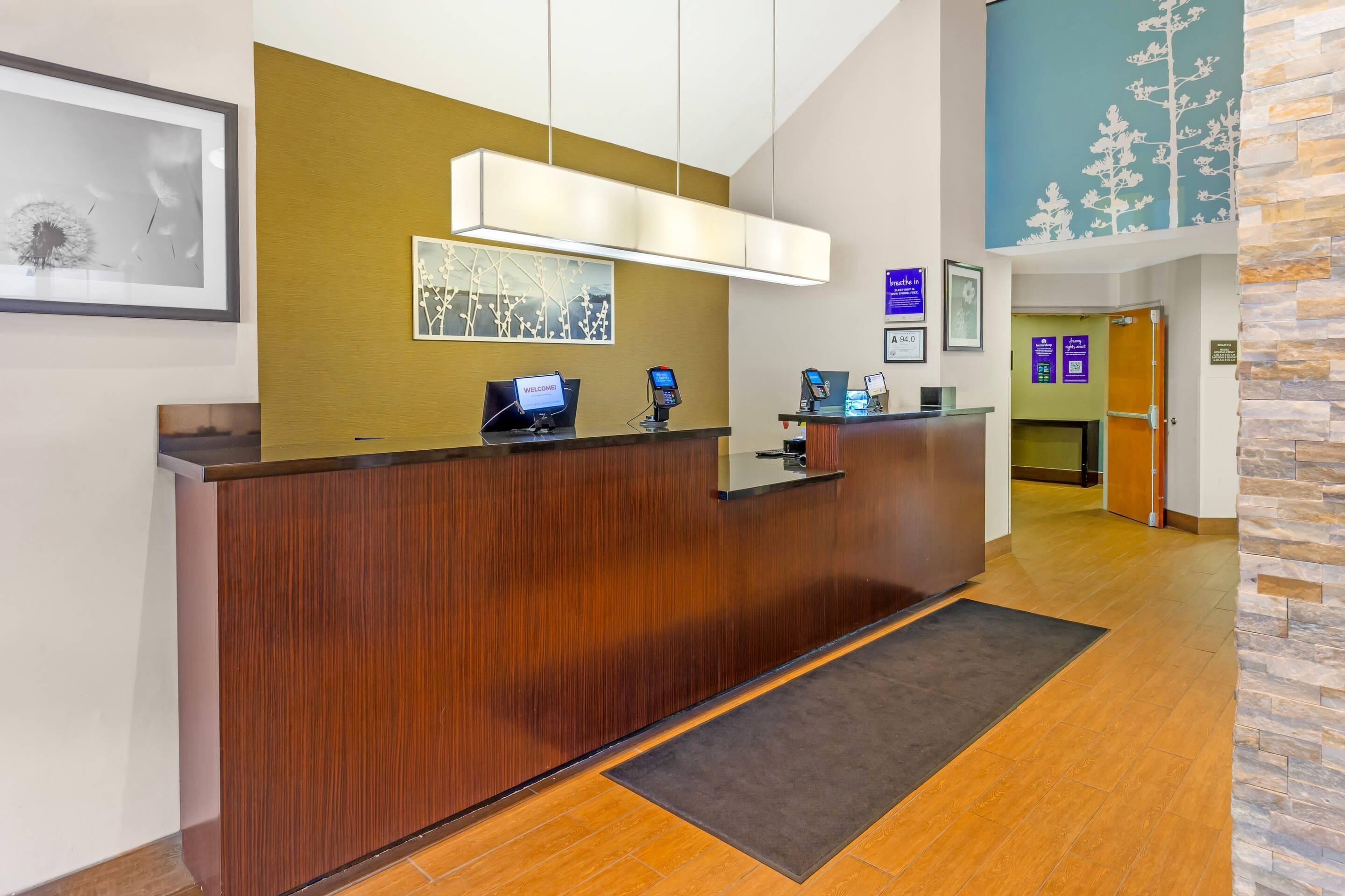 A reception desk with a digital display, framed artwork, and a stone accent wall.