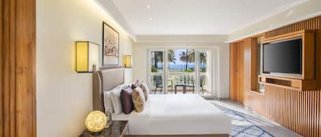 Quarto de hotel com cama, televisão, varanda com vista para palmeiras e painel de parede de madeira.