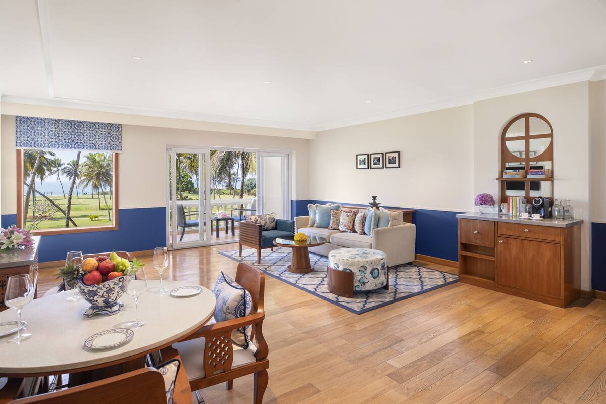 Amplia sala de estar con mesa de comedor, sofá y zona de cocina con armarios de madera.