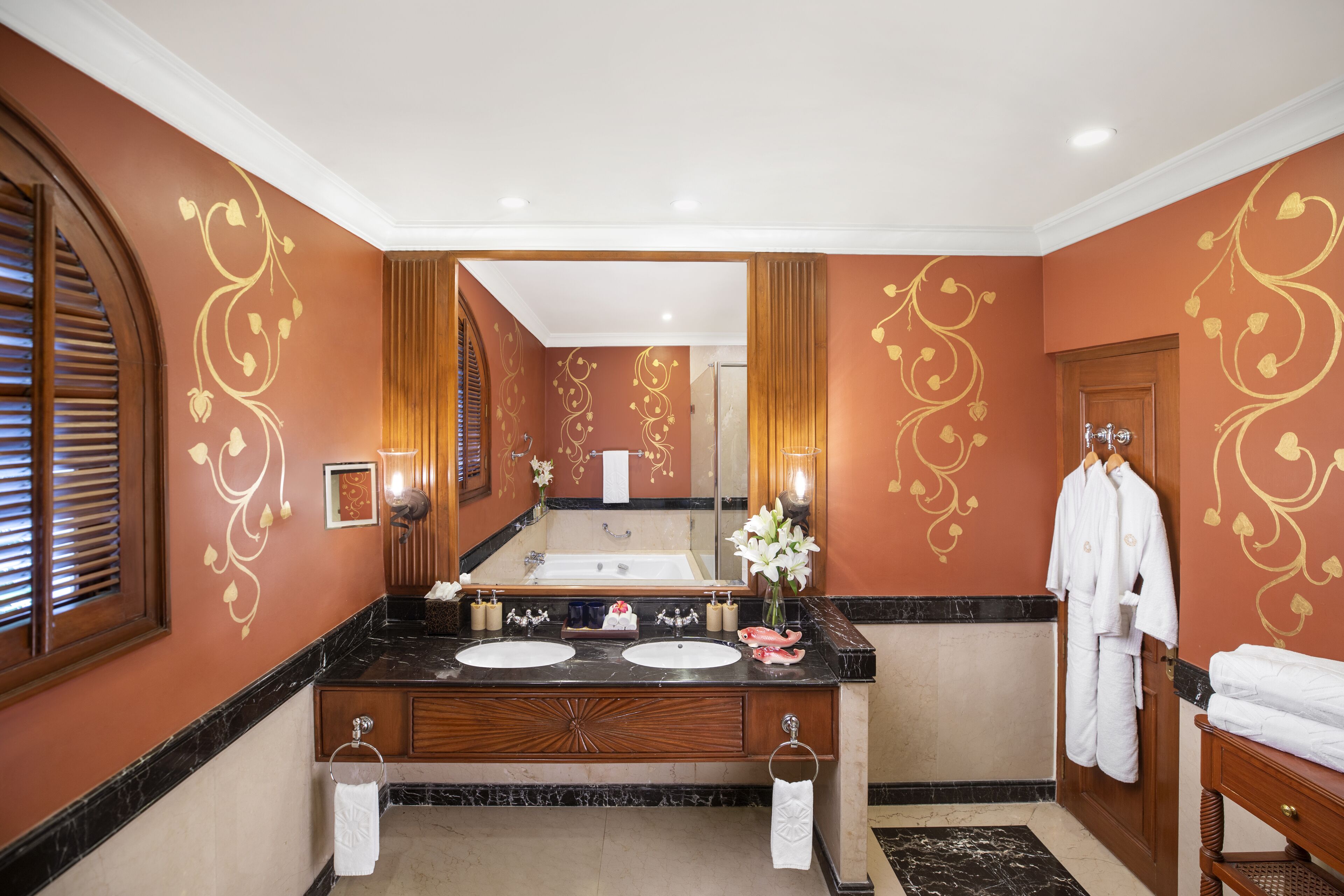 A bathroom with two sinks, a large mirror, and a wooden vanity.