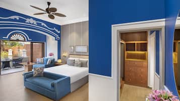 A bedroom with a large bed, a blue sofa, a ceiling fan, and a wooden wardrobe.