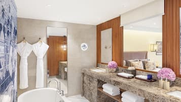 A modern bathroom with a large mirror, two sinks, a bathtub, and wooden paneling.