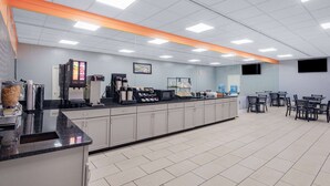 Una cafetería moderna y limpia con una barra larga, máquinas de café y zona de estar.