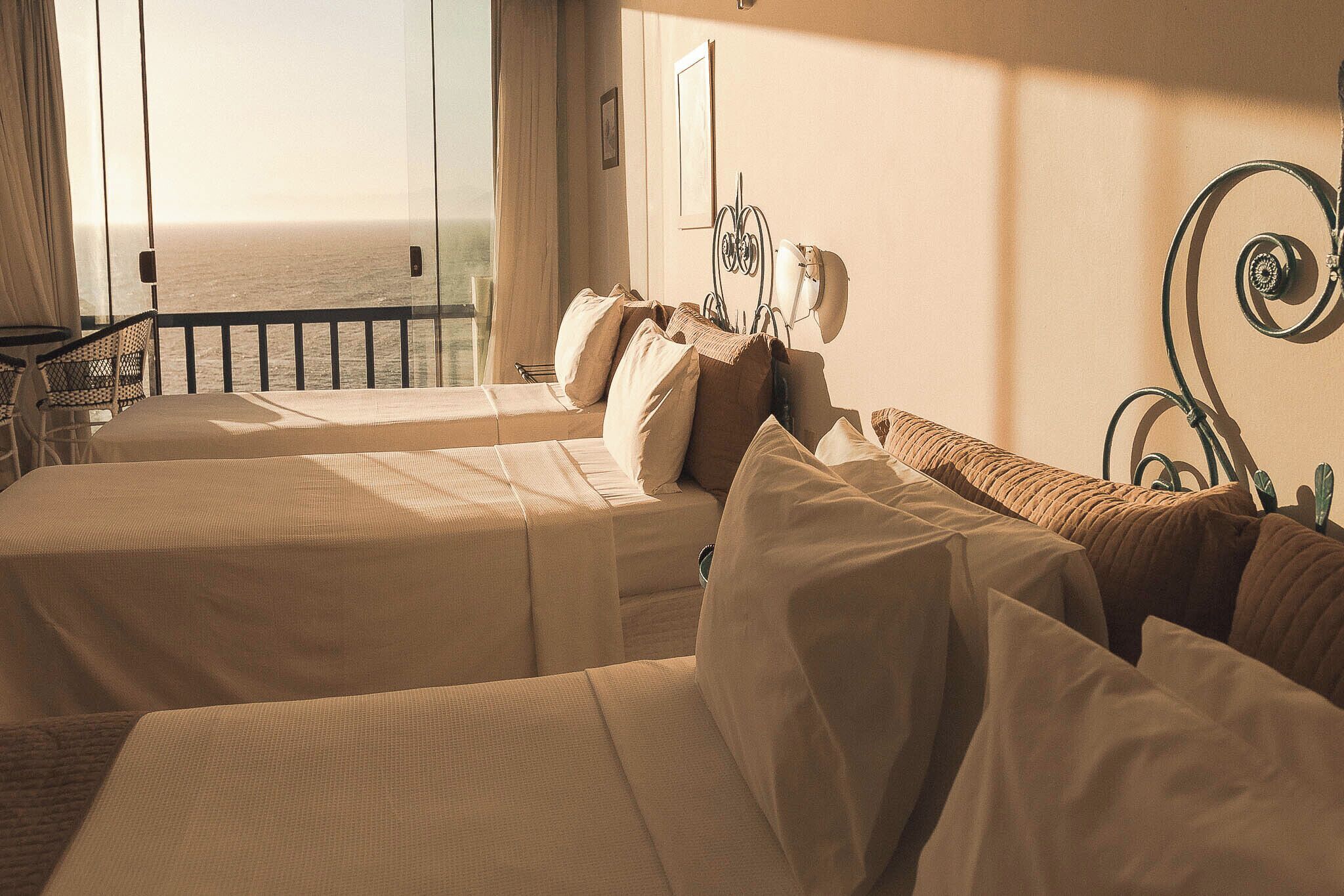 Camera d'albergo con due letti, un balcone e vista sull'oceano.