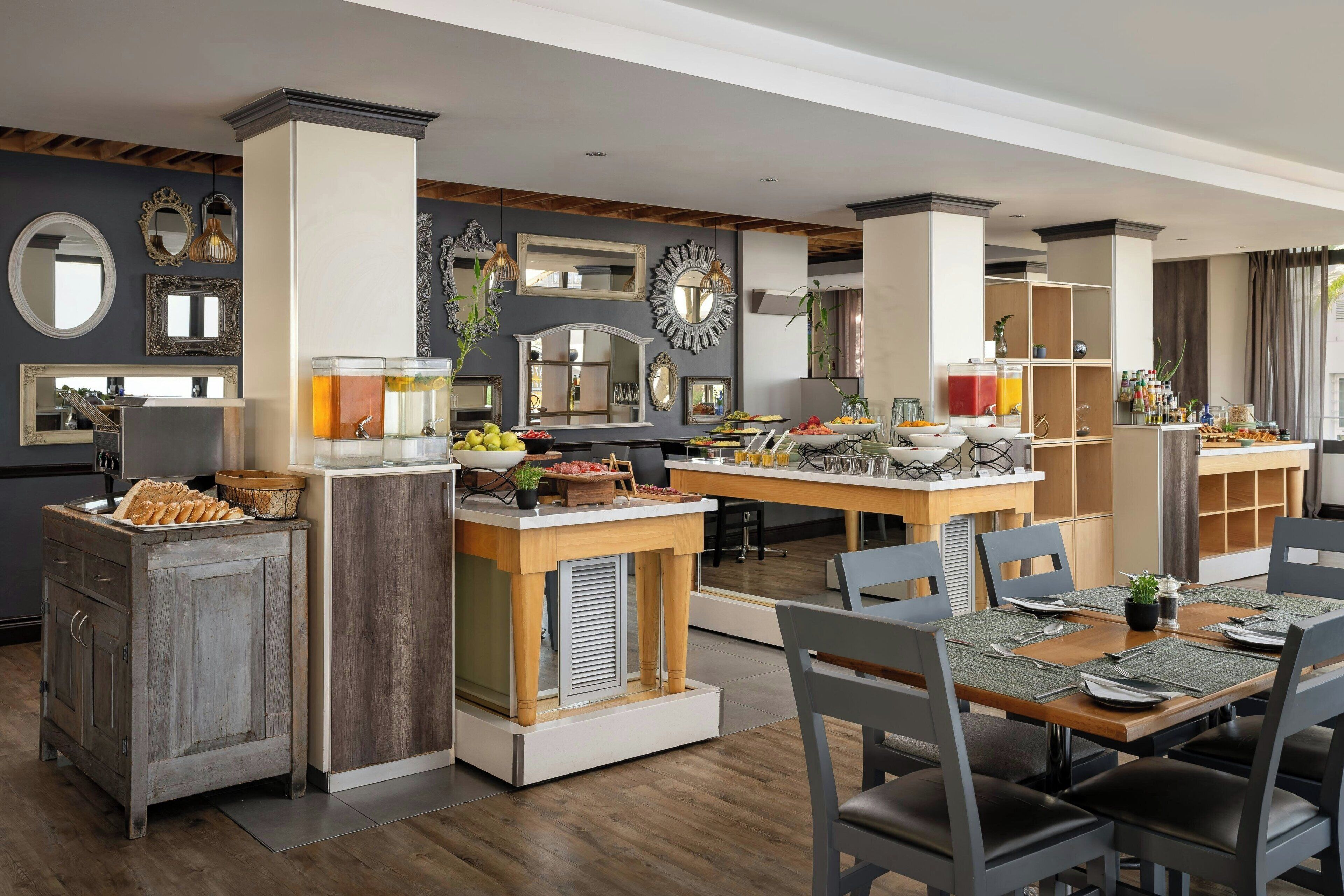 A modern kitchen with a central island, wooden cabinets, and a dining area with chairs and a table set for six.