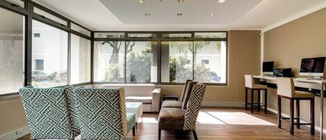 A modern interior with a dining area, a sofa, and a bar area with a computer.