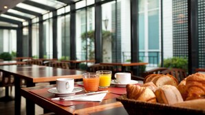 A breakfast setting with tables, chairs, and a variety of breakfast items including croissants and juice. - Hotel De La Jatte (Neuilly-sur-Seine)
