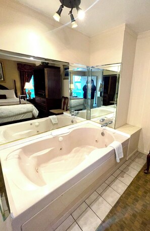 Habitación individual, 1 cama de matrimonio grande, no fumadores, bañera de hidromasaje | 1 dormitorio, colchones con acolchado adicional, escritorio