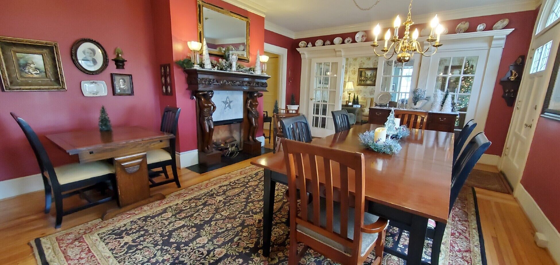Un comedor con una mesa y sillas de madera, un candelabro y una chimenea.