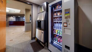 Un hall de hotel con una máquina expendedora llena de bebidas y aperitivos.