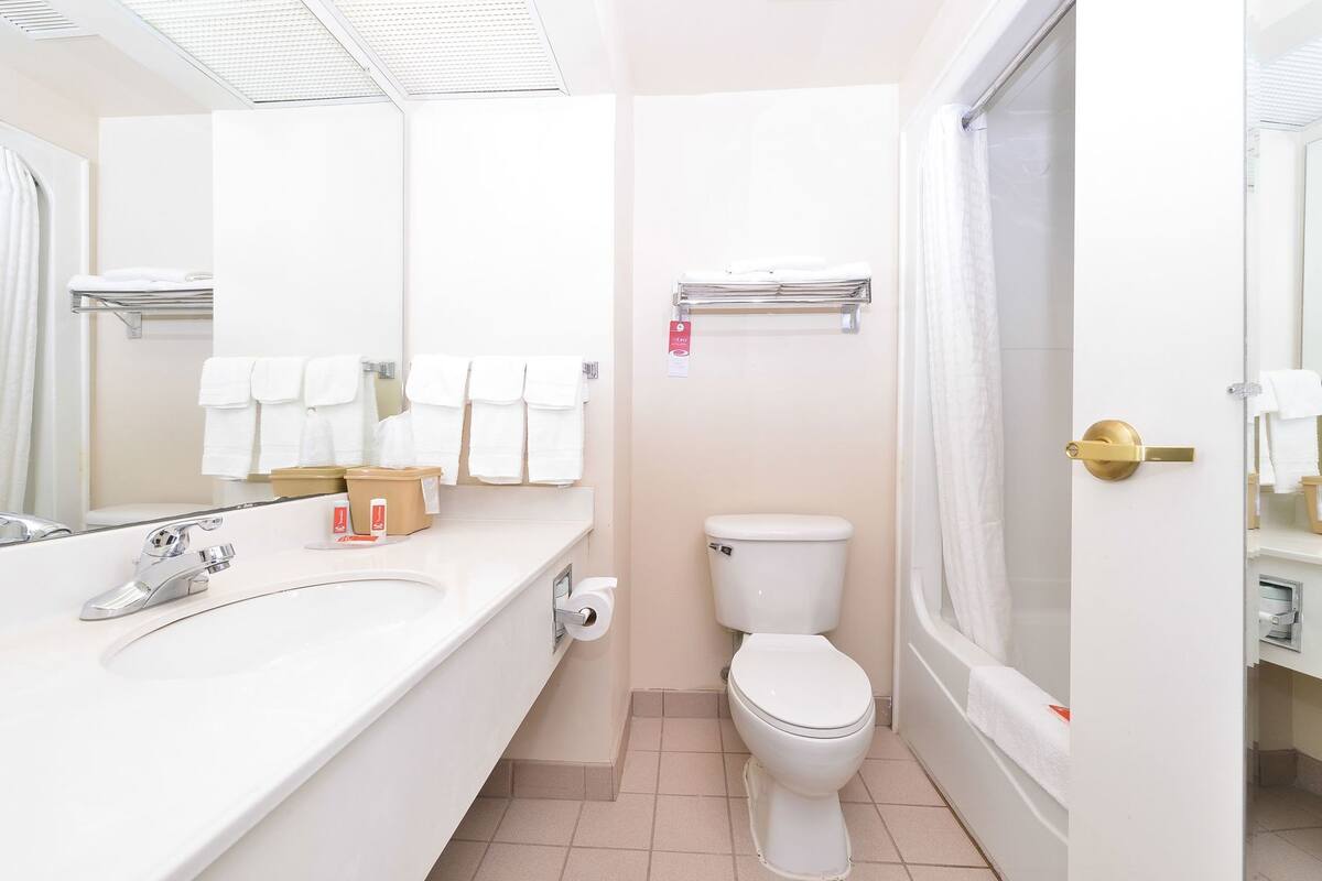 A bathroom with a sink, toilet, and shower area.