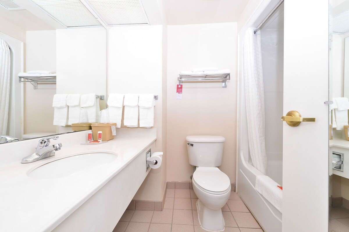 A bathroom with a sink, toilet, and shower area.