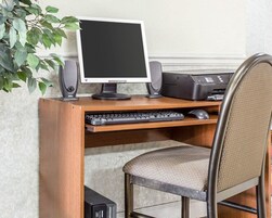 Escritorio de madera con computadora, teclado, ratón e impresora.