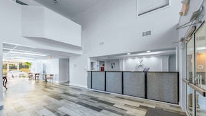 A reception area with a modern design, featuring a reception desk, seating area, and a view of the outside.