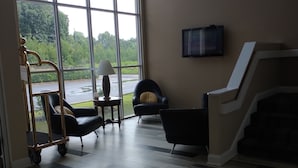 A spacious room with large windows, a fireplace, and a television.