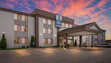 Experience the serene atmosphere of this hotel, featuring a flat facade and a series of windows, with a covered walkway leading to the main entrance.