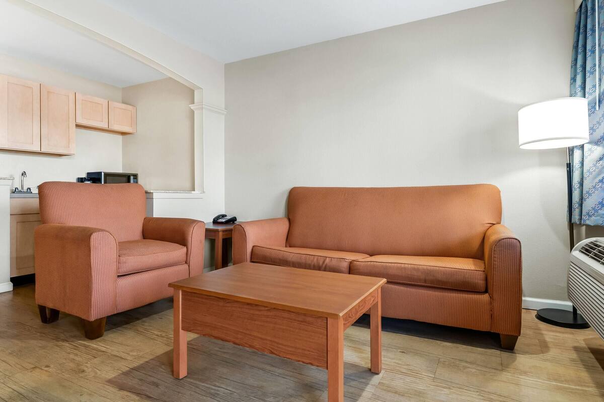A modern living room with a sofa, armchair, and coffee table.