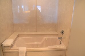 Bathroom features a large bathtub, separate shower area, and a sink.