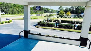 A motel with a covered parking area, a sign for the Western Motel, and a landscaped garden with a fountain. - Western Motel Thomasville  (Thomasville)