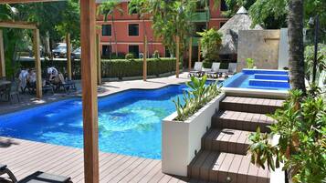 A pool area with lounge chairs and a small pool.