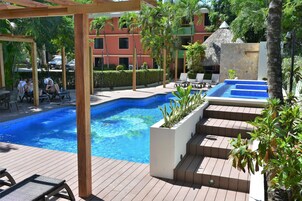 Zona de piscina con sillas de descanso y una piscina pequeña.