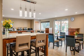 A modern kitchen with a marble countertop, stainless steel appliances, and hanging pendant lights. - MainStay Suites Dubuque at Hwy 20 (Dubuque)