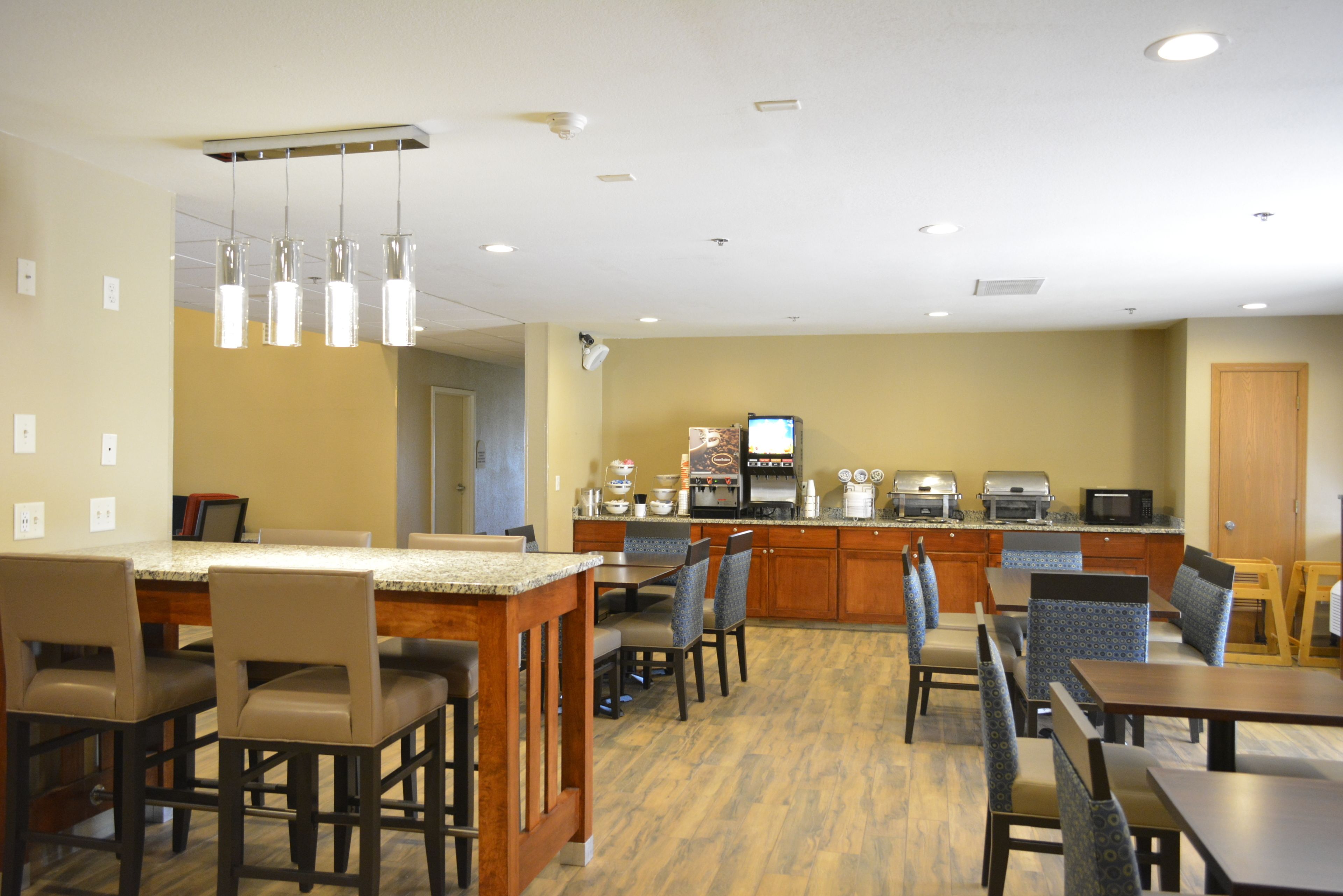 Una cocina de hotel con zona de bar, asientos y estación de café.