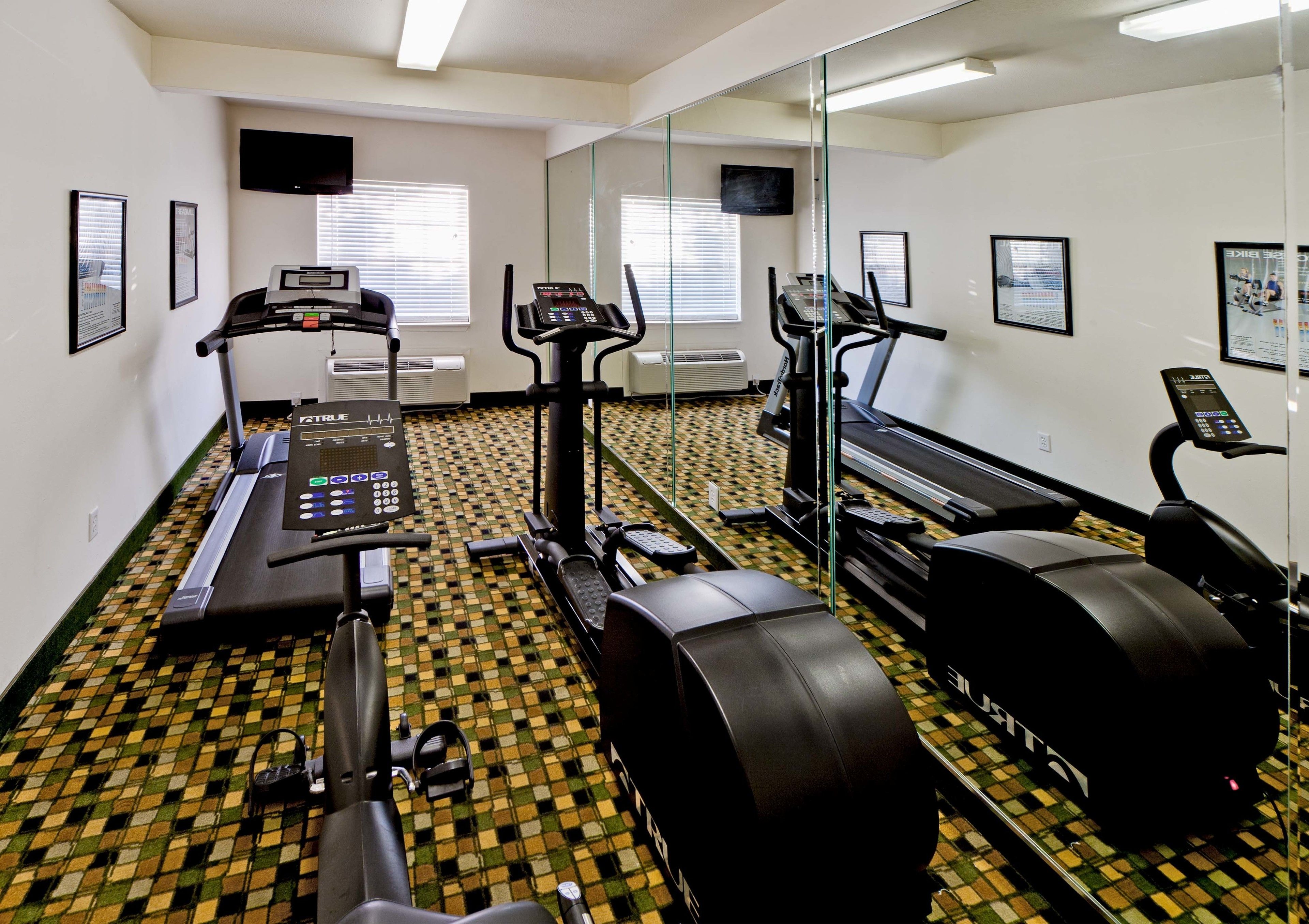 A fitness center with treadmills, elliptical machines, and a stationary bike.
