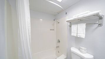 Un baño con bañera, inodoro y cortina de ducha.