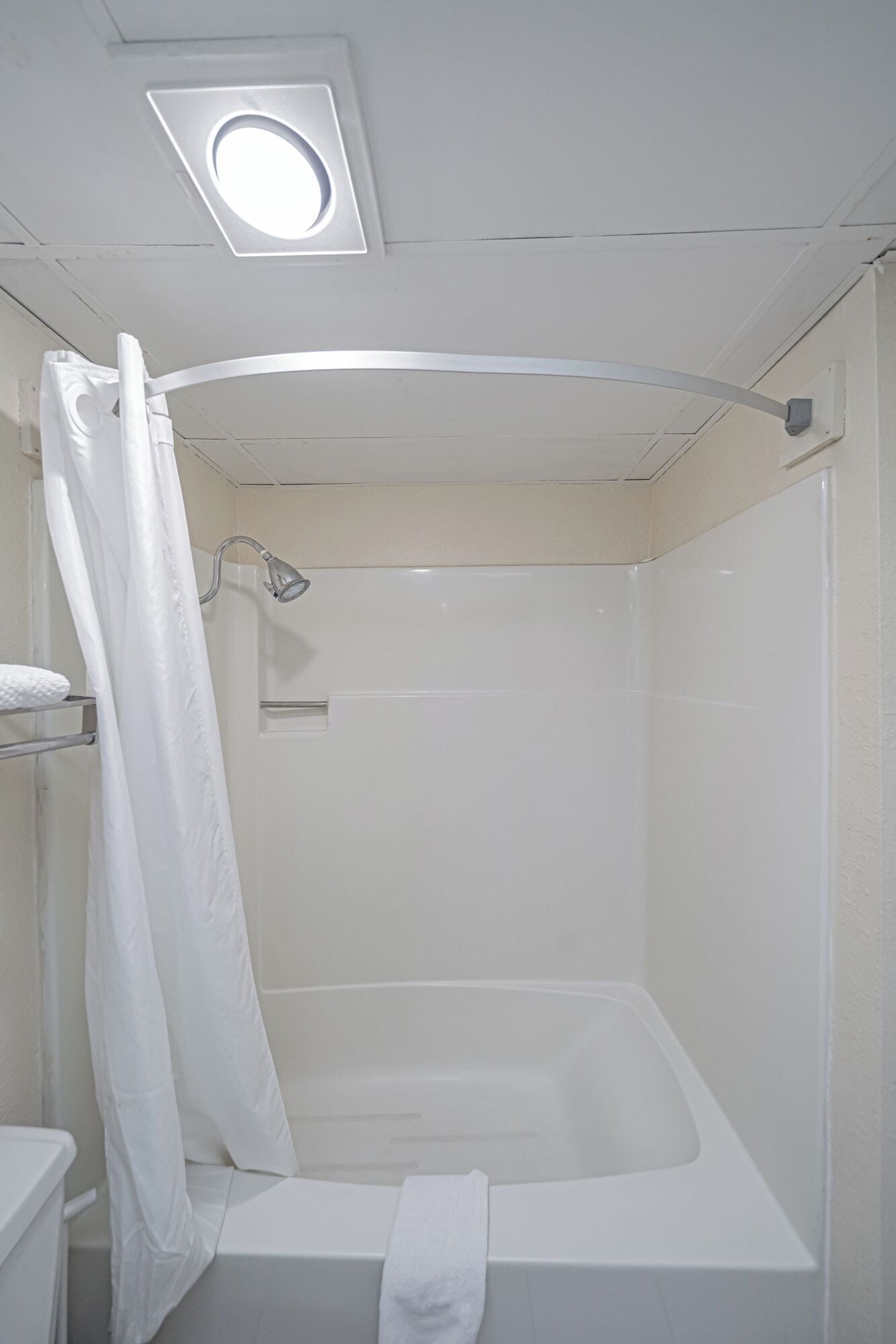 A bathroom with a bathtub, a shower curtain, and a towel rack.