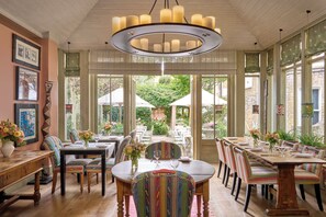 A dining area with a large table, chairs, and a hanging light fixture. - Number Sixteen Hotel, Firmdale Hotels (London)