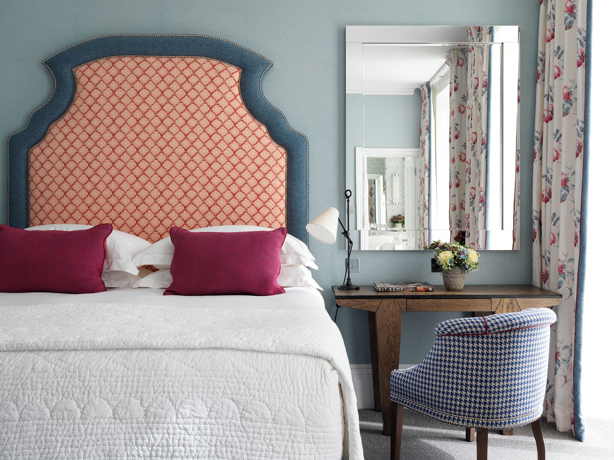 A bedroom with a large bed, a desk, and a chair.