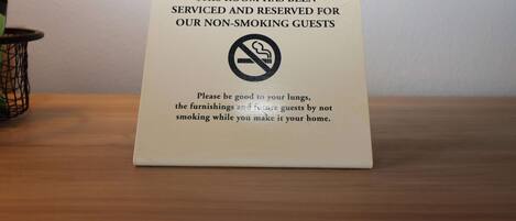 A sign on a table indicating the room is reserved for non-smoking guests.