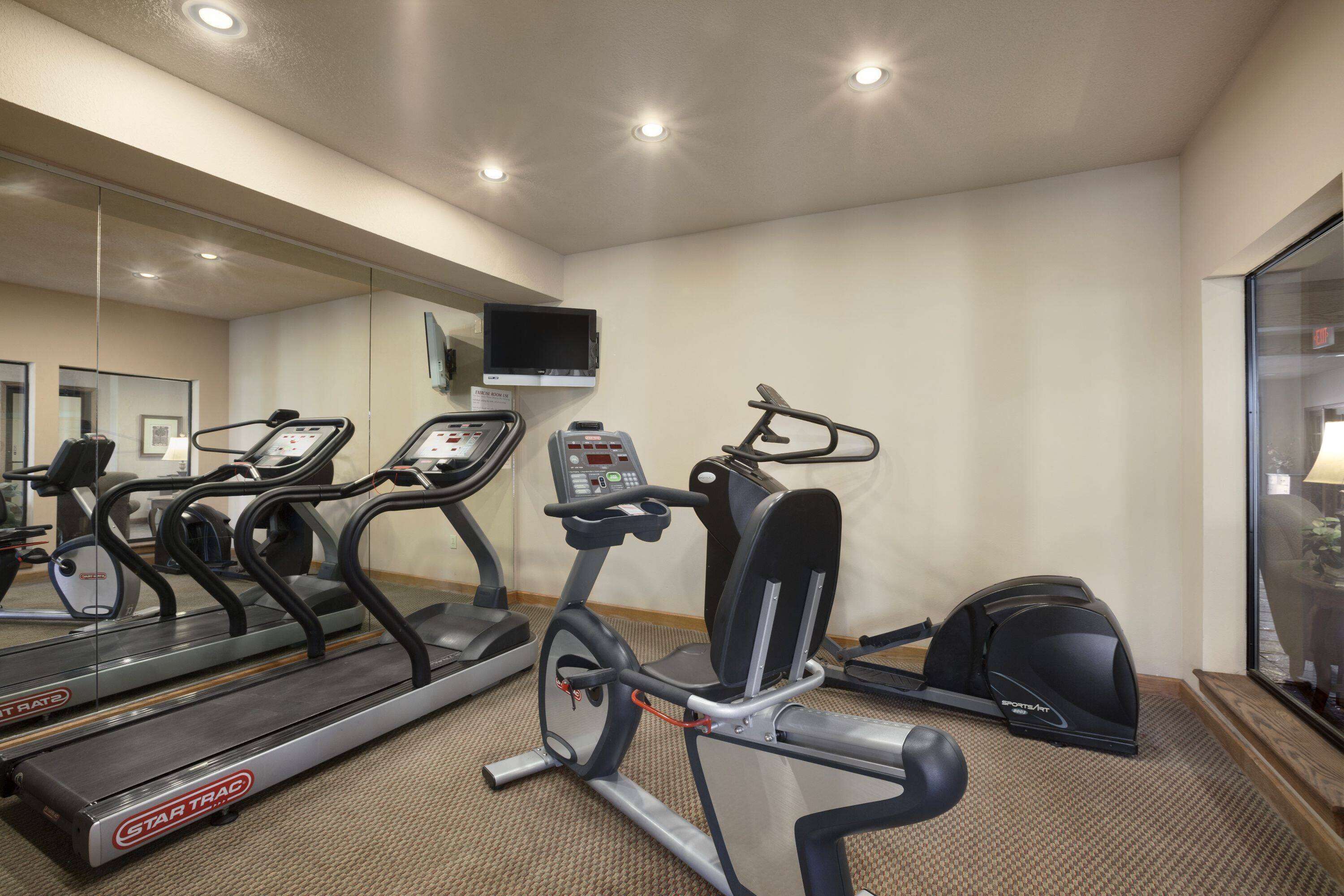 A hotel fitness center with treadmills, an elliptical, and a stationary bike.