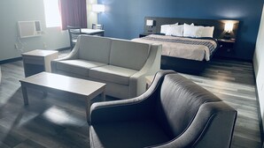 Ein Hotelzimmer mit Bett, Sofa, Schreibtisch und Stuhl.