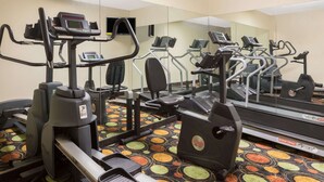 A gym with multiple treadmills, ellipticals, and a mirrored wall. - Super 8 by Wyndham Duson Lafayette West Area (Duson)