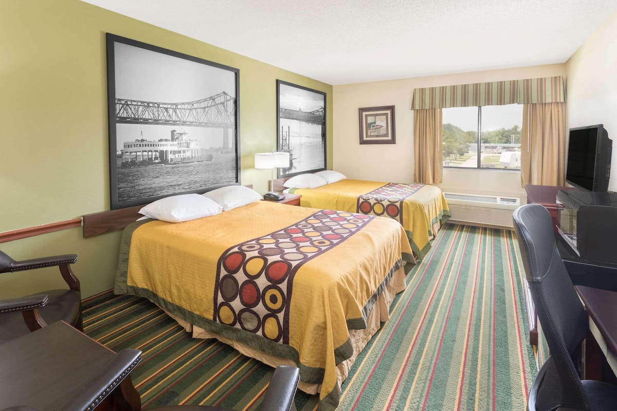Een hotelkamer met twee bedden, een televisie, een bureau en een raam met uitzicht.